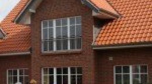 Einfamilienhaus mit Sprossenfenstern und Terrassentür in weiß
